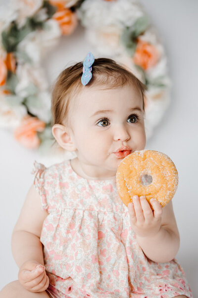One year old girl eating a donut