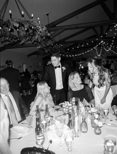 Couple in wedding attire sit on a vintage wood staircase and lean in for a kiss