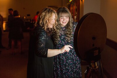 two guests using a wedding photo booth