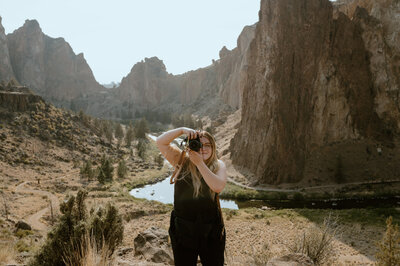 A photographer stands in front of Smith Rock State Park, Oregon.