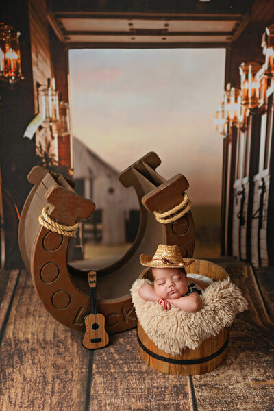 Sleeping cowboy on his horseshoe during his denver newborn session with h&N photography