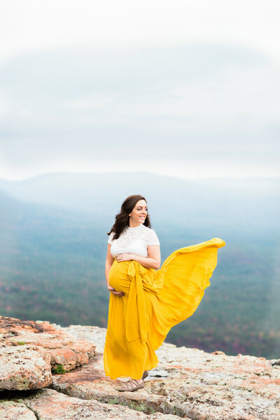 maternity photo shoot of woman in yellow skirt