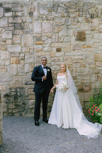 A couple in wedding attire, the bride in a gown and the groom in a blue tux, share a first look inside the Washington Hotel in Washington DC. The photo was taken by Get Ready Photo.