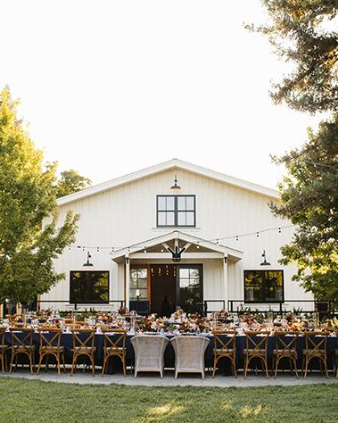 Outdoor wedding reception in front of a white venue