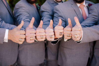 groomsmen sign Aggie Gig'em in tuxedos captured by wedding photographer in Texas