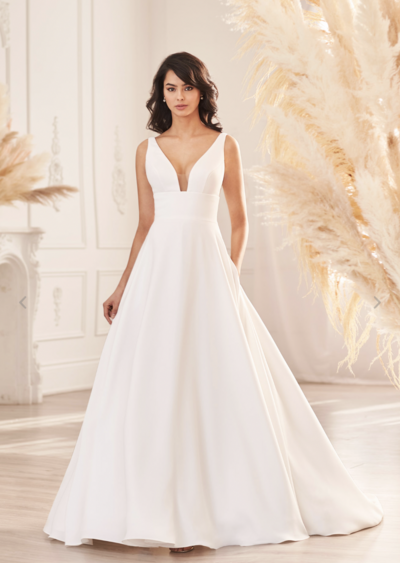 Silk Dupioni Wedding Dress. Silk Dupioni gown with bateau neckline and low back. V-shaped Italian Tulle inserts at side seams on bodice. Flared skirt fitted through hips with princess seams to hem.