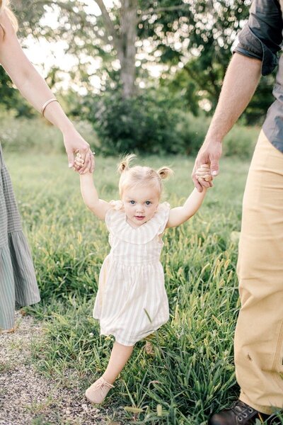A heartwarming portrait of a child with their two parents, captured by Emily Barbara, a family photographer in Milwaukee.