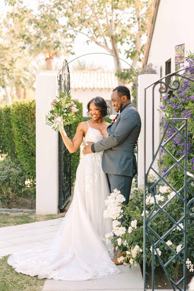 Bride and Groom celebrating after their wedding and cheering with the bride holding her tropical bouquet in the air