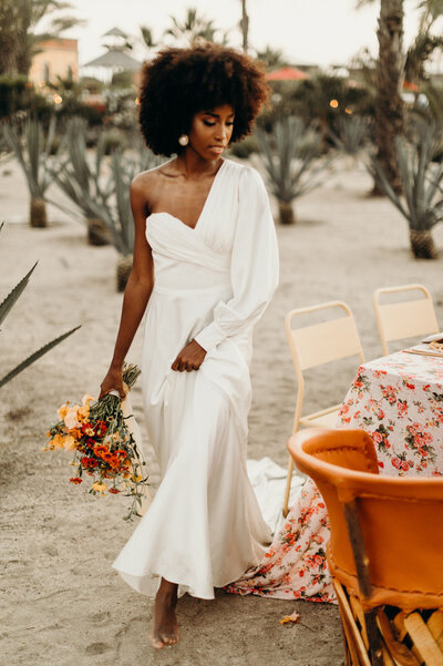 Bride with Bouquet walking around reception table by MemoryBox Photography