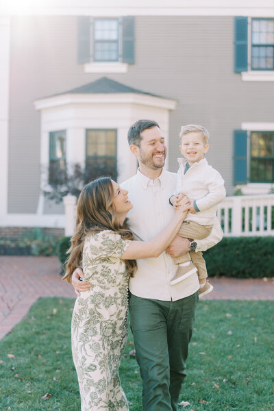 mom and dad laughing with toddler during family photos