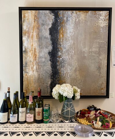 table with wine and flowers with large painting