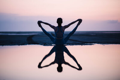 Water reflection of woman doing Yoga at Laguna Madre Bay