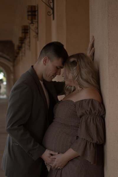 Parents gazing lovingly at their newborn baby wrapped in a swaddle, taken during a family photography session