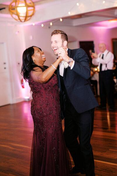 Bride on wedding guests shoulders during dance set at Glen Foerd Estate in Philadelphia, PA