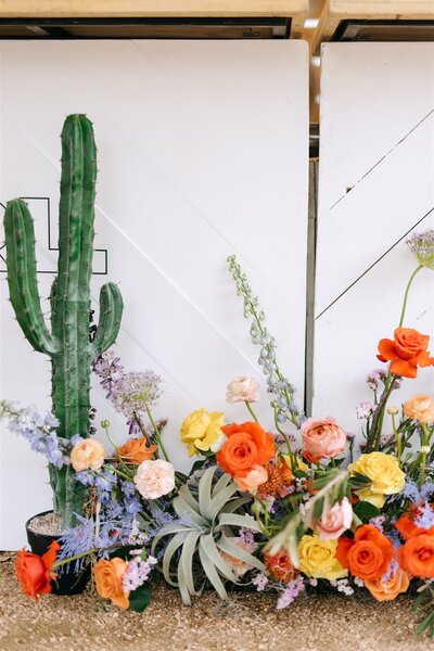 Eclectic wedding floral arrangement with orange roses and desert-inspired textures, perfect for bold Austin event decor.