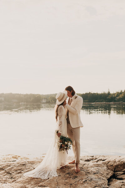 wedding couple, near a lake looking lovingly into each others eyes