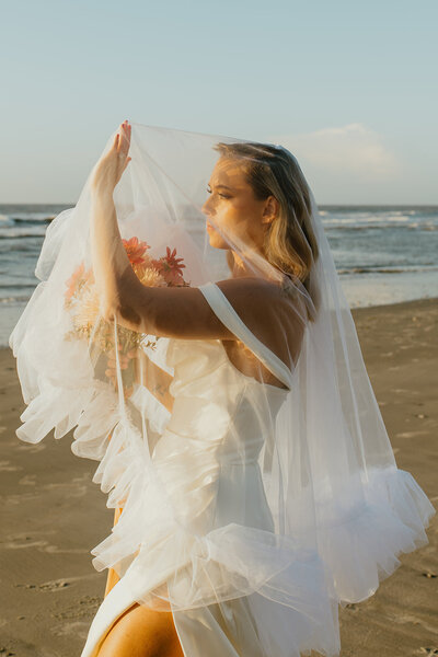 bride under veil at beach