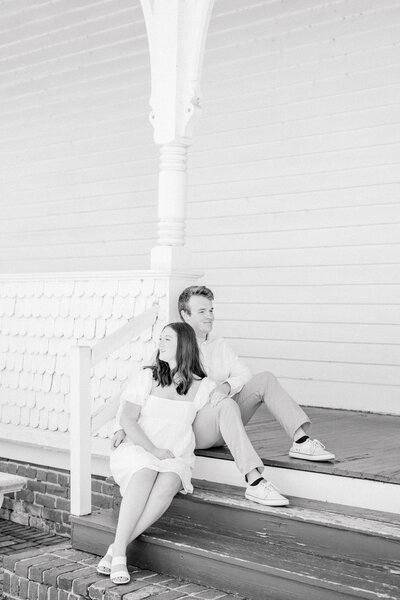 A couple sitting on the steps of a historic chapel taking in the scenery together