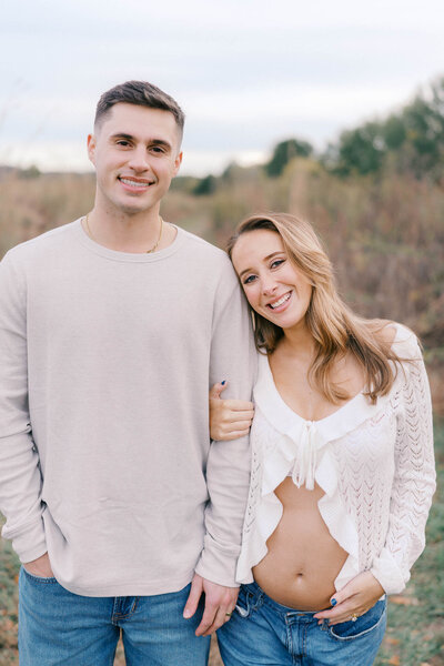 pregnant woman holds husband's hand at seven islands state birding park in kodak tennessee