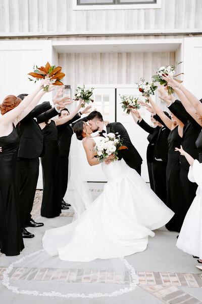 Bride and Groom kissing in front of bridal party