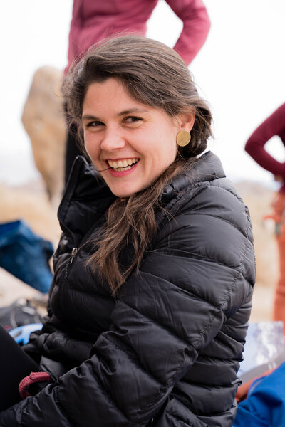 Sierra Farquhar, adventure photographer smiles at the camera wearing Bri Bol earrings
