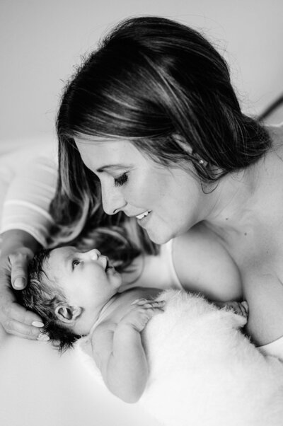 Mother embracing newborn tenderly in newborn photos