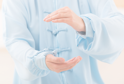 Person in blue robe with hands moving in a circular motion