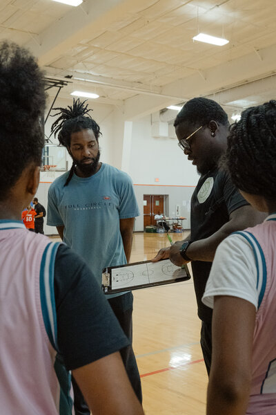 Coaches and young athletes demonstrating teamwork and leadership, representing the core values of Full Circle Basketball TX, a nonprofit youth basketball program in Fort Worth.