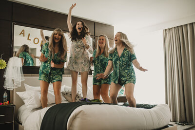 group of women standing on bed while laughing