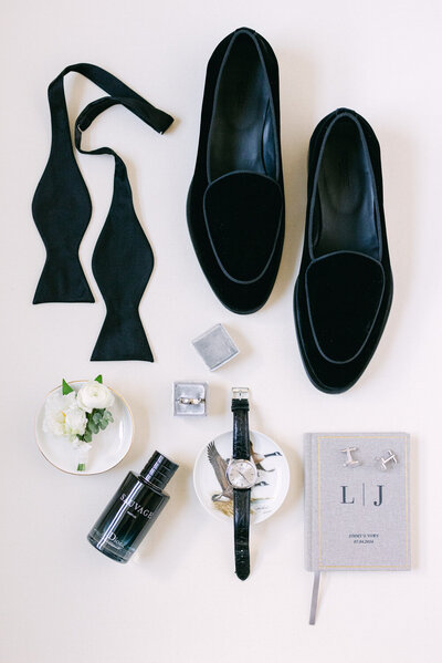 This meticulously arranged layflat photograph showcases the groom's wedding day details at the iconic Banff Springs Hotel. The elegant ensemble of accessories and personal touches perfectly encapsulates the sophistication and style of the occasion.