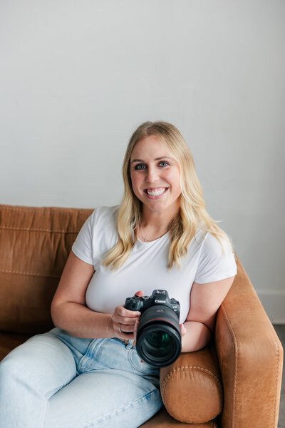 Branding headshot of a female photographer holding her camera, captured by Zoe Evans Photography for women in business.