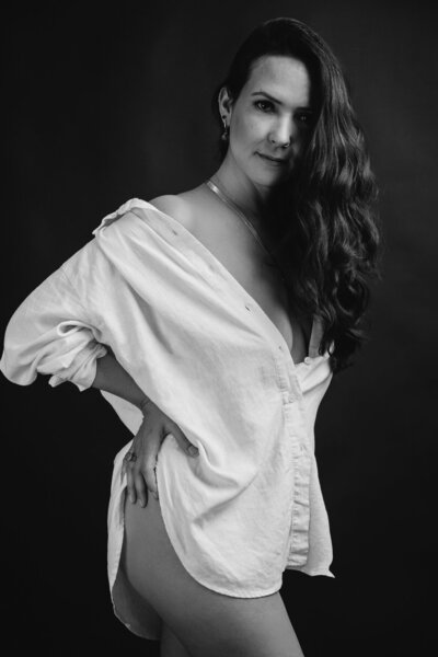Woman with long dark hair wearing only an oversize white shirt