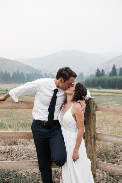 Bride and groom laugh together at an orchard wedding