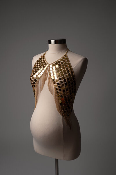 Pregnant woman wearing a statement pearl shoulder piece in a fine art maternity photo