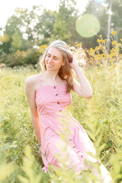 Portrait of senior girl sitting in a filed of wild flowers