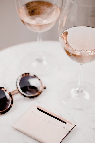 Sunglasses and wine glasses on table in Parisian cafe
