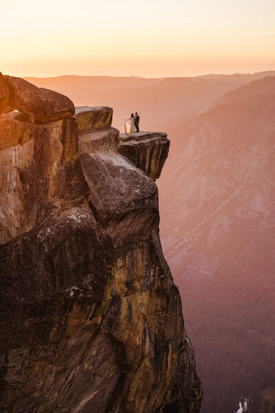 wedding couple posed on cliffside at Yosemite National Park