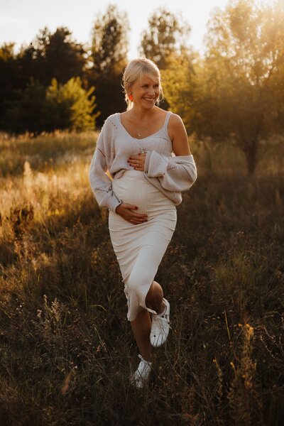 Golden Hour Shooting von lachender Frau mit Babybauch