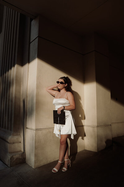 woman soaks up the sun along the street in downtown Tampa celebrating her graduation