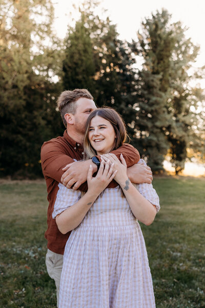 Engaged couple cuddle during their engagement shoot. Photo by Acacia & Grace Wedding Photography