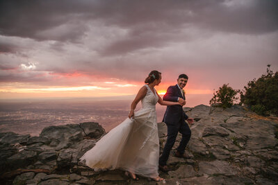 Bride and groom laughing during colorful sunset