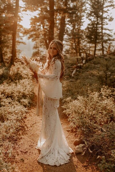 A bride on her elopement day standing in the forest