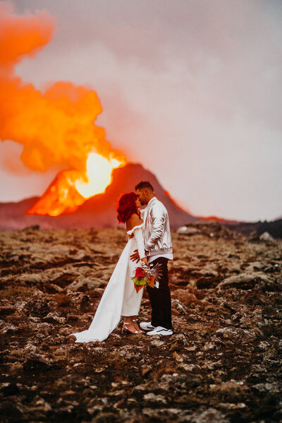 Bride & groom kissing in front of an active volcano in Iceland!