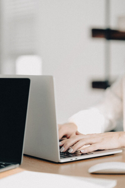 A person focused on typing on a laptop computer, showcasing a modern workspace with a showit template design.
