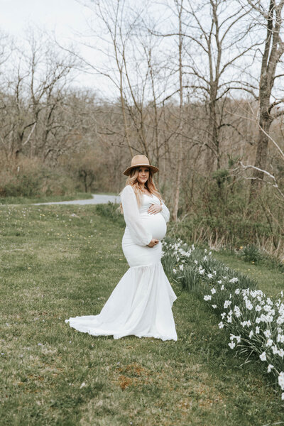 Woman cradling her baby bump during maternity session