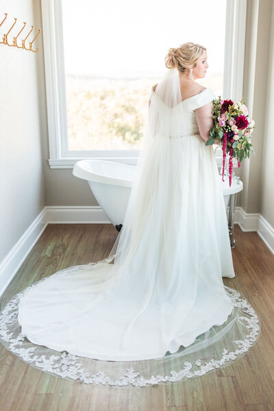 A bride poses in her wedding dress in the bridal suite.