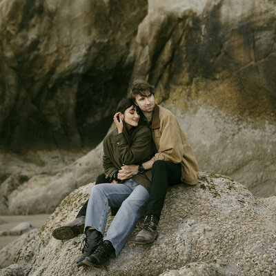 Couple sitting on rock on the beach