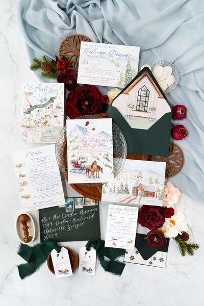 Charming winter wedding invitation suite with detailed illustrations of mountains, chapels, and sleighs by E Stokes Creations, featuring a watercolor map of Beaver Creek, Colorado.