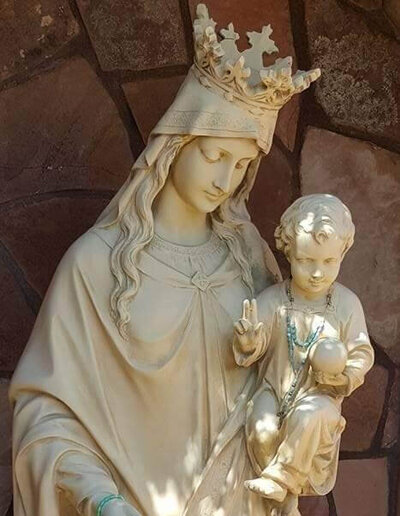 Cream statue of  Mother Mary wearing a crown holding a child