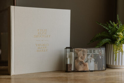 Handcrafted wedding album and keepsake box displayed on a wooden table, captured by Rainstorm Photo & Video to showcase timeless, heirloom wedding photography products.